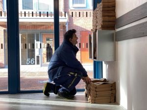 Medarbetare fyller på med matavfallspåsar i miljöhuset