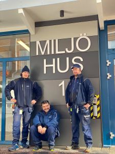 Tre personer från personalen står utanför miljöhus i Tynnered. 