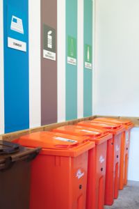 Sopkärl på rad i ett miljöhus.