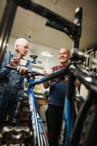 Två män med en cykel emellan sig.