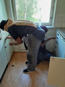 Två tjejer skruvar loss köksinredning.