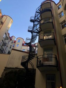 Balkonger och spiraltrappa på en fasad.