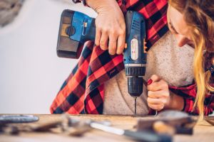 En kvinna borrar i en metallkrok