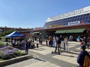 Fullt med folk på Brunnsbotorget. Vår maskot Reture kramar ett barn.