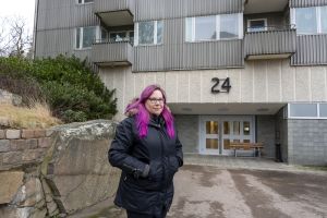 Kvinna som står utomhus framför en port. 