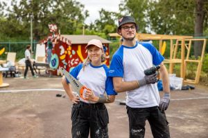 En kvinna med en såg och en man med en borrmaskin.