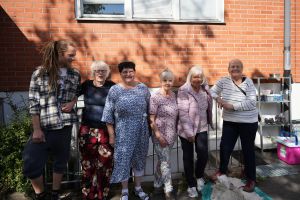 En yngre man och fem äldre kvinnor ler mot kameran.