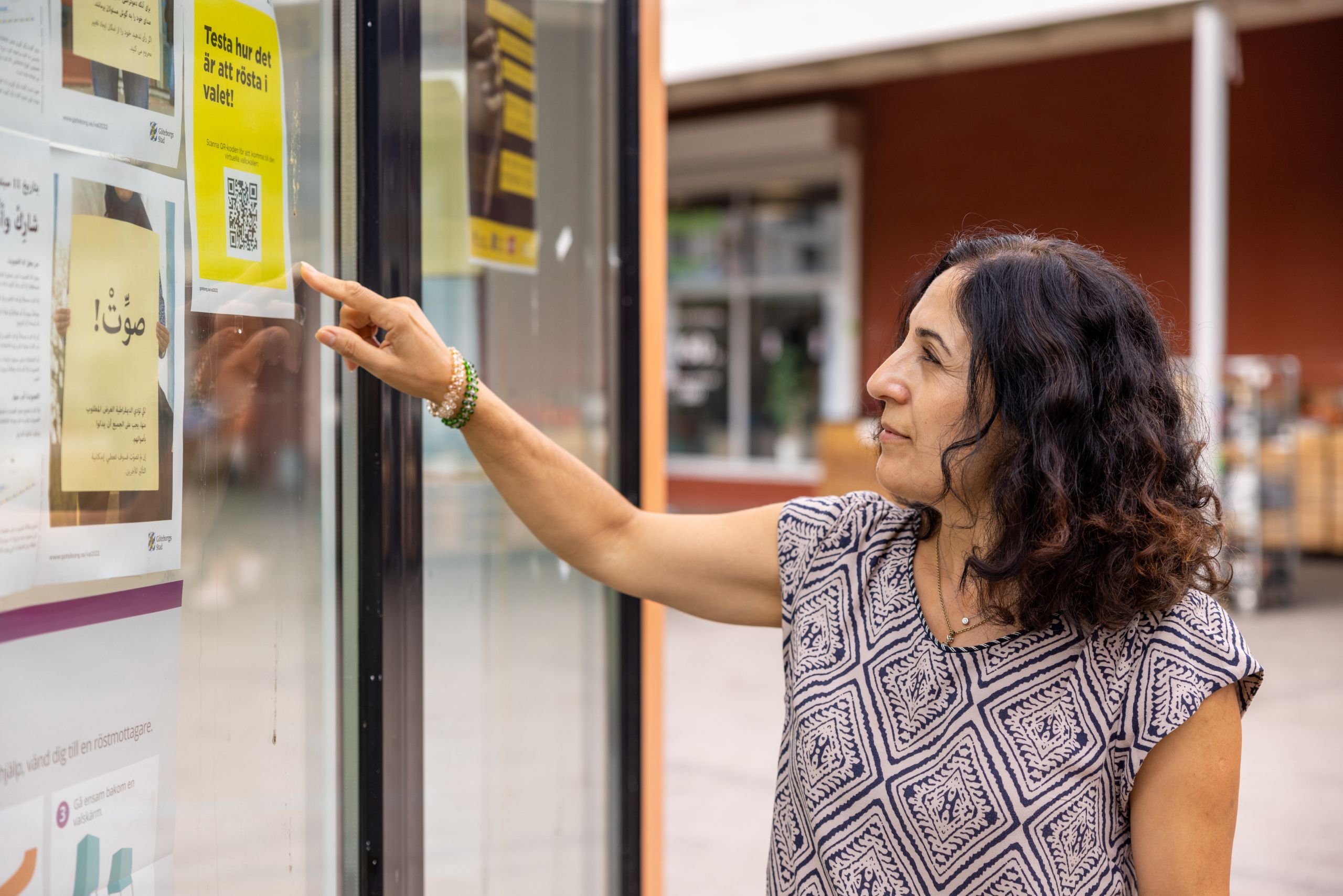 Kvinna pekar på affisch