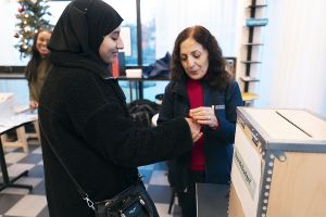 Två kvinnor vid en röstlåda.