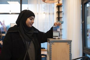 En kvinna lägger en röstsedel i en valurna.