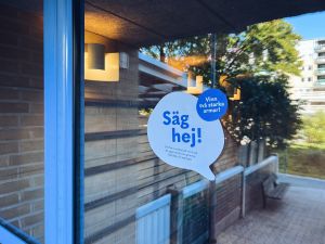 Ett foto av en dekal där det är skrivet "Säg hej!"