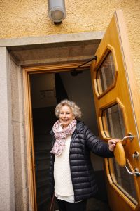 En kvinna tittar ut genom en port.