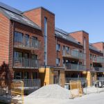 Nybyggda hus vid Robertshöjdsgatan. I förgrunden syns byggställningar och byggarbetare.