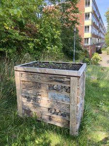 Ett insektshotell som står på marken