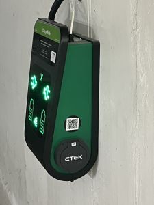 Bild på en laddpunkt som sitter på en garagevägg. 