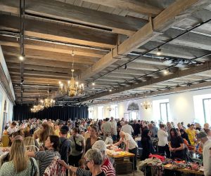 Loppis inomhus med massa människor i förgrunden.