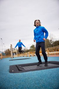 Två personer hoppar på studsmattor.