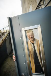 En man tittar ut genom en dörr.