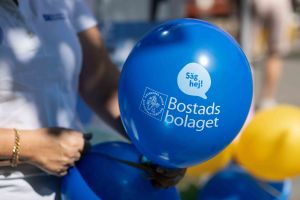 En hand håller en bostadsbolagetballong.