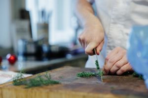 Händer som finstrimlar dill.