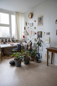 Bilden visar en ateljé med konst på väggarna.