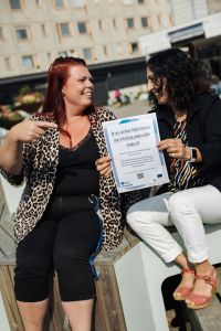 Två kvinnor tittar på ett diplom.