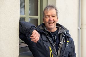 En man tittar in i kameran och ler.