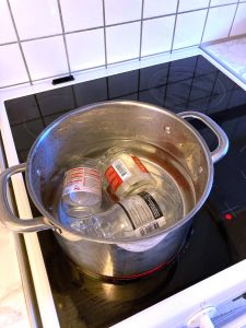 Glasburkar som kokar i vatten.