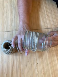 Hand som fäster snöre på glasburk.