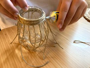 Hand som fäster snöre på glasburk.