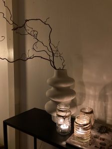 Ljus i glasburk med snören runt.