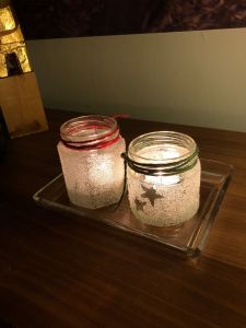 Frostade glasburkar med ljus i.