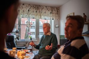 Hyresgäst som berättar med gester på födelsedagsfika