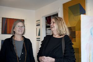 Två kvinnor ler in i kameran.