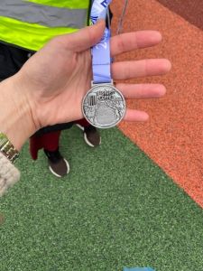 En medalj i en hand. Det står Biskopsloppet på medaljen.