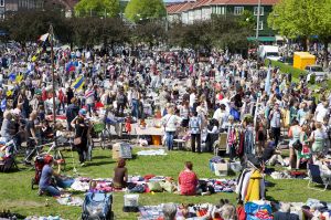 Loppis med massor av människor i en park. Både som köper och säljer.