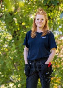 Bilden föreställer en kvinna i bostadsbolagets arbetskläder.