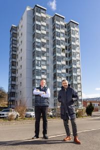 Två män står framför ett hus i Södra biskopsgården.