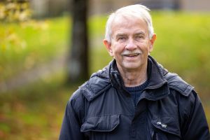 En äldre man som tittar in i kameran.