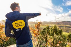 Man ser ryggen på en man som pekar mot utsikten.