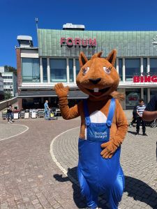 Bostadsbolagets maskot ReTure (ekorre i blåbyxor) vinkar in i kameran.