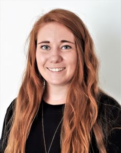 En kvinna ler in i kameran.