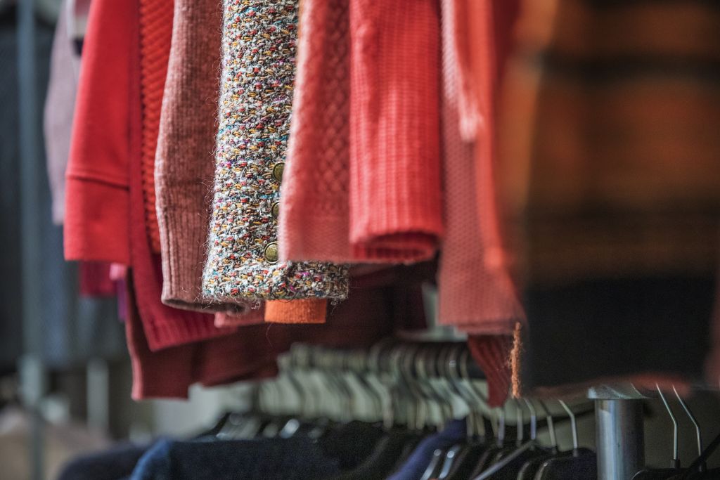 Ett foto av detaljer av upphängda tröjor sorterade efter färg.