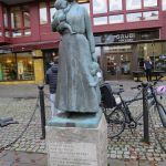 Skulptur som föreställer en kvinna med ett barn i famnen och ett i handen.