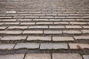 Närbild på gata gjord av gatsten.
