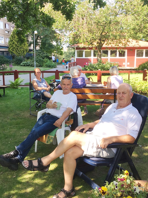 Två hyresgäster från Trygghetsboendet i Rannebergen sitter ute i det gröna och pratar med varandra.