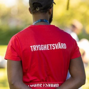 Man ser ryggen på en kille och på ryggen står det Trygghetsvärd.