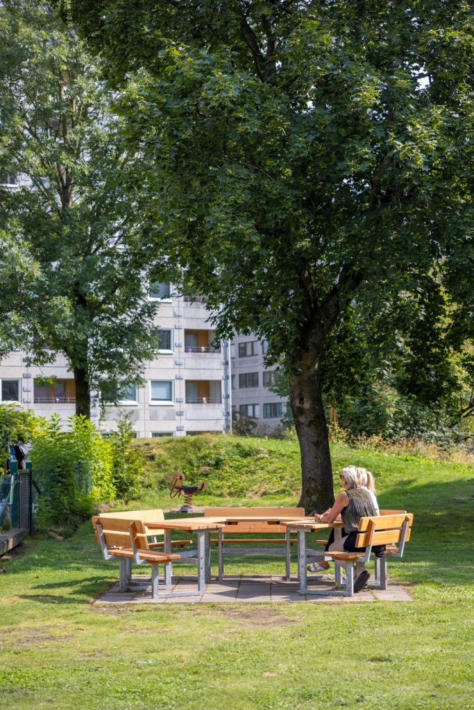 Två kvinnor på avstånd vid ett utebord.