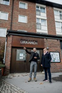 En man pekar och en kvinna tittar på.