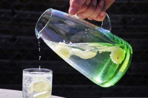 En kanna med vatten hälls upp i ett glas.